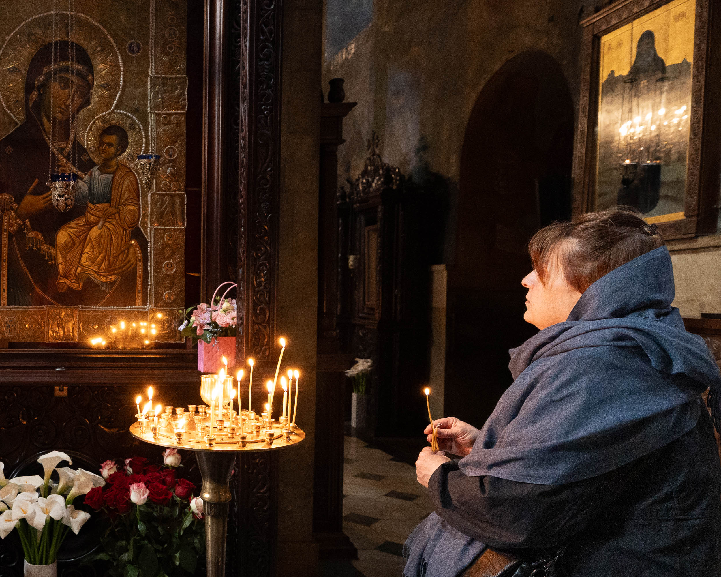 Woman praying before icon